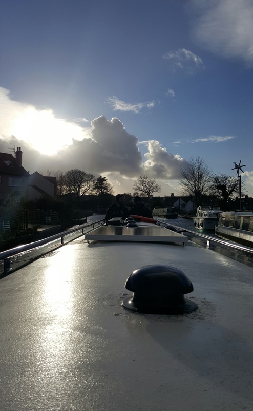 View of blue cloudy sky at Hest Bank looking over the top of a hire canal boat on the Lancaster canal