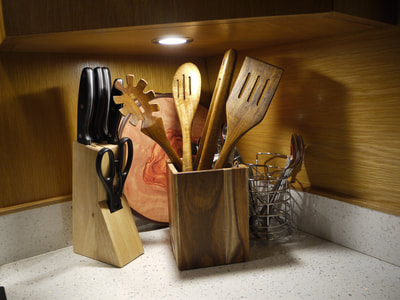 a photo of utensils on a hire narrowboat including knives, spatulas, salad tongs and chopping boards